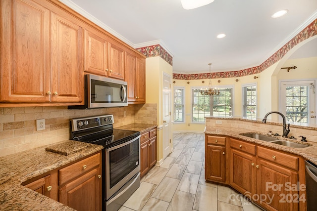 kitchen featuring sink, light stone counters, appliances with stainless steel finishes, and ornamental molding