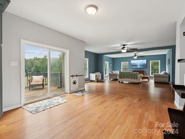 unfurnished living room with light hardwood / wood-style flooring and ceiling fan