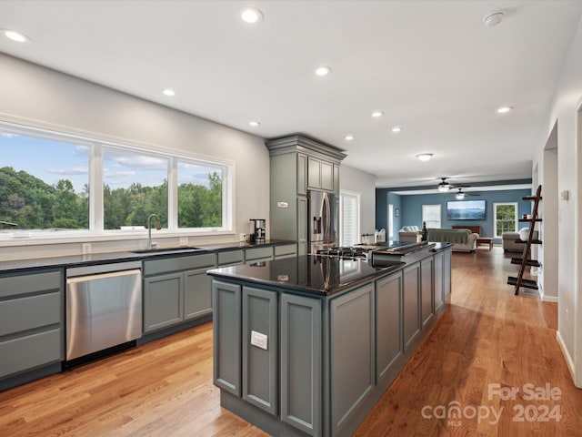 kitchen featuring gray cabinetry, sink, a kitchen island, and stainless steel appliances