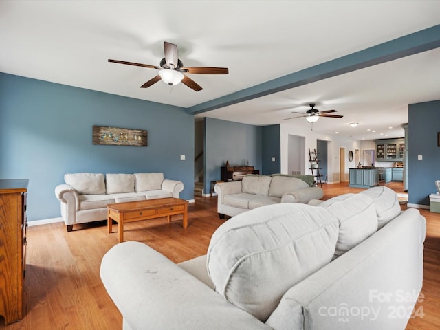 living room with ceiling fan and light wood-type flooring