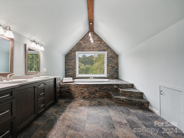 bathroom featuring lofted ceiling with beams, vanity, and a tub