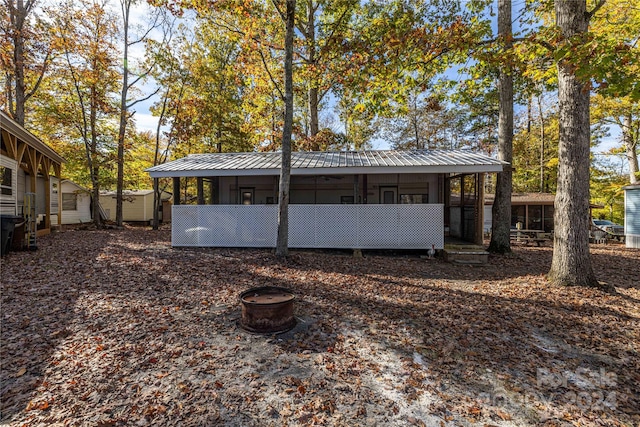 rear view of property with an outdoor fire pit