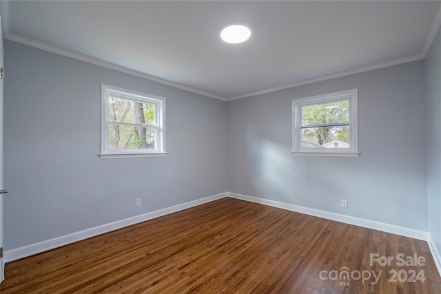 empty room with hardwood / wood-style floors, a healthy amount of sunlight, and ornamental molding