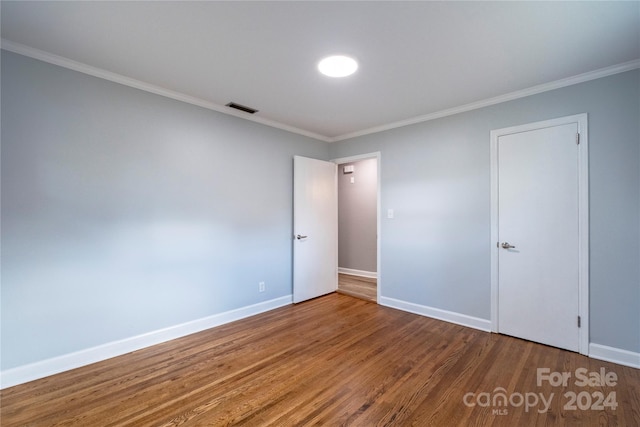 spare room with hardwood / wood-style flooring and ornamental molding