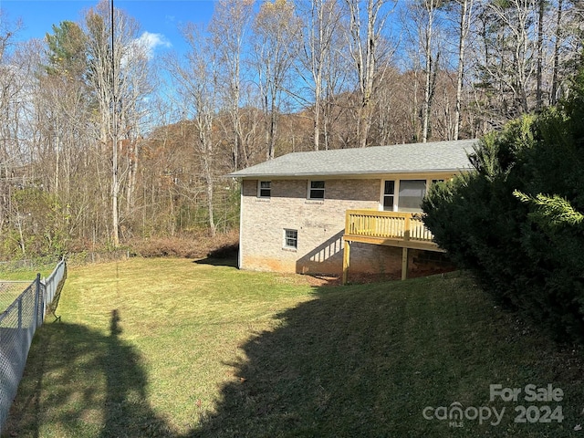 view of side of home featuring a yard and a deck