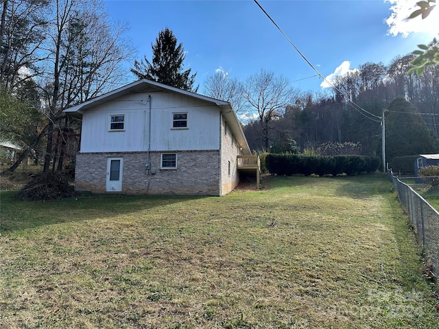 view of side of home with a yard