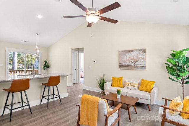 living room with high vaulted ceiling, ceiling fan, dark wood-type flooring, and sink