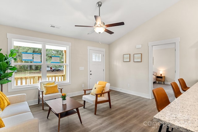 living area with ceiling fan, dark wood-type flooring, and lofted ceiling