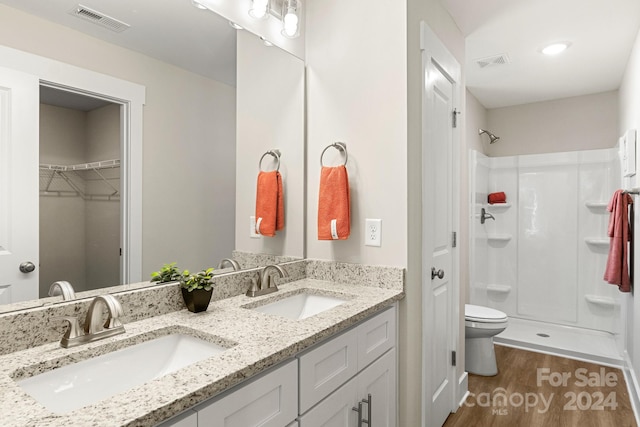 bathroom featuring hardwood / wood-style floors, toilet, a shower, and vanity