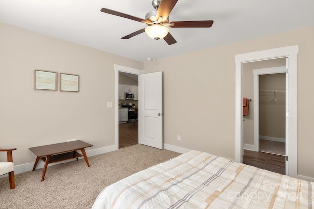 carpeted bedroom with ceiling fan, a spacious closet, and a closet