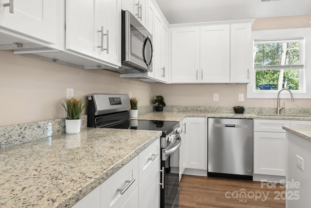 121 Orchard St, Forest City, NC 28043 - kitchen featuring a sink, light stone counters, stainless steel appliances, white cabinetry, and dark wood-type flooring