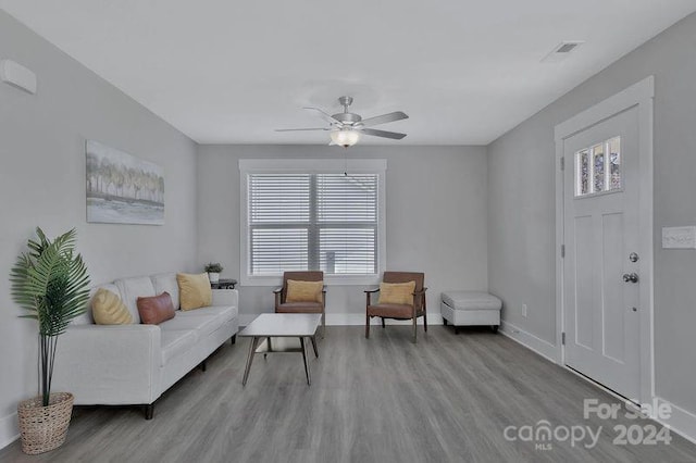 living room with ceiling fan and light hardwood / wood-style flooring