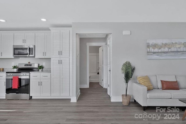 kitchen featuring white cabinets, light wood-type flooring, and appliances with stainless steel finishes