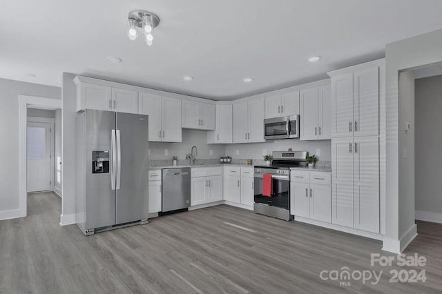 kitchen featuring white cabinets, light wood-type flooring, and stainless steel appliances