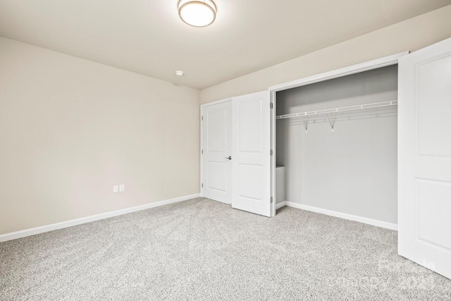 unfurnished bedroom with light colored carpet and a closet