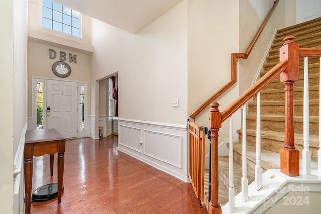 foyer entrance featuring a towering ceiling and hardwood / wood-style flooring