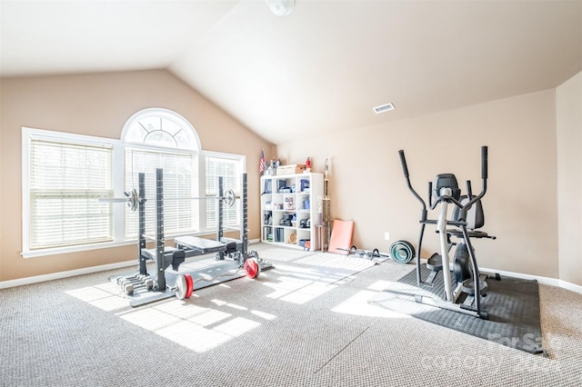 exercise room with light colored carpet and vaulted ceiling