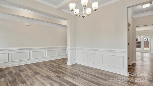 unfurnished dining area with dark hardwood / wood-style floors, an inviting chandelier, and ornamental molding