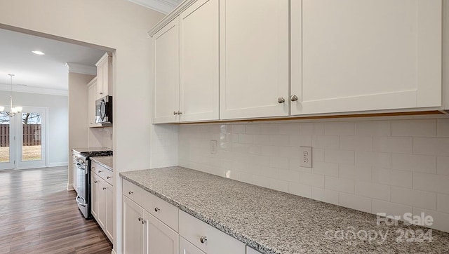 kitchen with dark hardwood / wood-style flooring, light stone countertops, appliances with stainless steel finishes, and crown molding