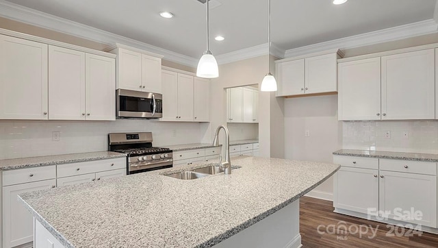 kitchen featuring white cabinets, a center island with sink, stainless steel appliances, and sink