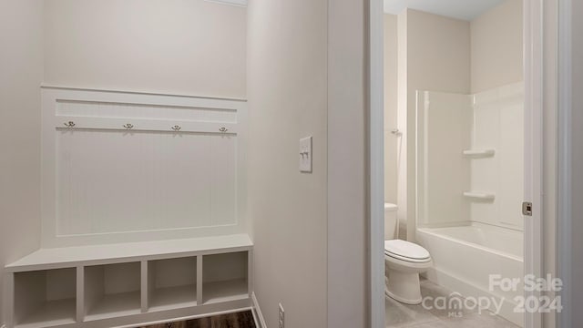 bathroom featuring wood-type flooring, toilet, and shower / bathtub combination