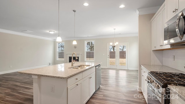 kitchen featuring a center island with sink, appliances with stainless steel finishes, hanging light fixtures, sink, and white cabinets