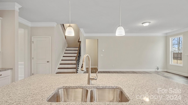 kitchen featuring hanging light fixtures, light stone counters, and wood-type flooring