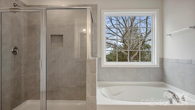 bathroom featuring a healthy amount of sunlight and separate shower and tub