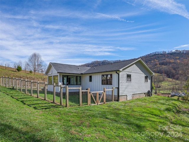 rear view of property featuring a lawn and a mountain view