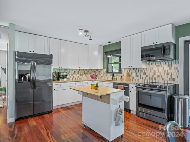 kitchen with appliances with stainless steel finishes, dark hardwood / wood-style flooring, tasteful backsplash, pendant lighting, and white cabinetry