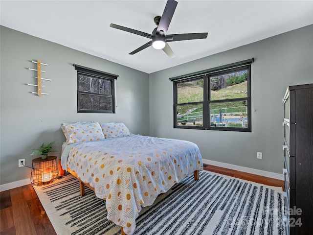 bedroom with ceiling fan and dark wood-type flooring