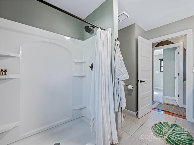 bathroom featuring curtained shower and tile patterned flooring