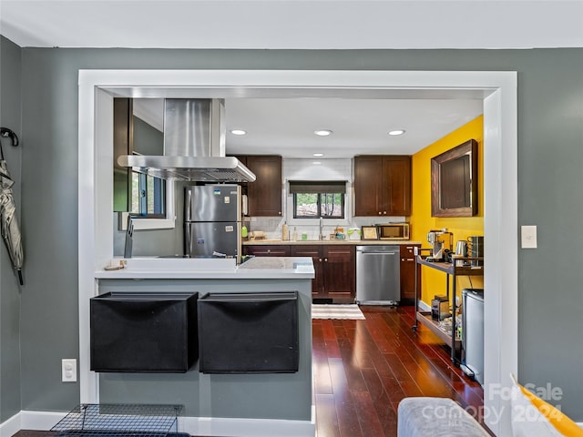 kitchen featuring sink, decorative backsplash, dark hardwood / wood-style flooring, island exhaust hood, and stainless steel appliances