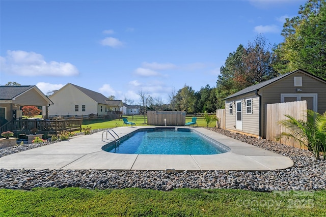 view of swimming pool with a lawn, a patio area, and an outdoor structure