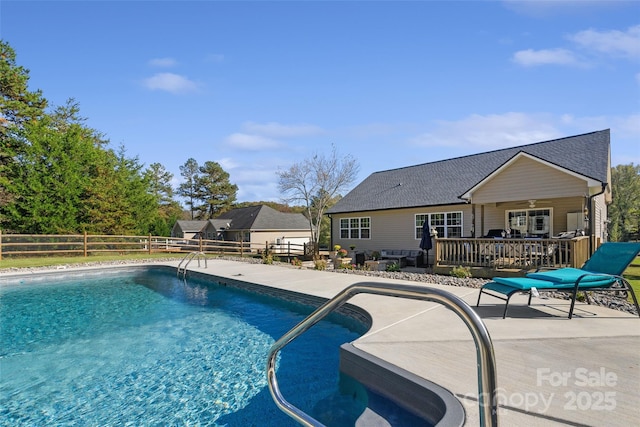 view of swimming pool with a deck, ceiling fan, and a patio area