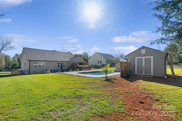 view of yard with a fenced in pool and a shed