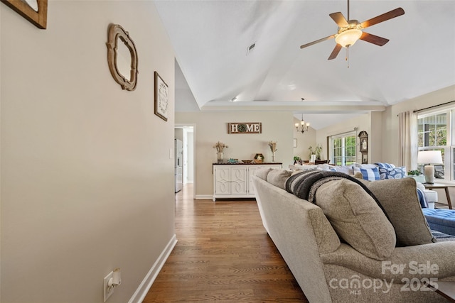 living room featuring hardwood / wood-style floors, ceiling fan with notable chandelier, and lofted ceiling