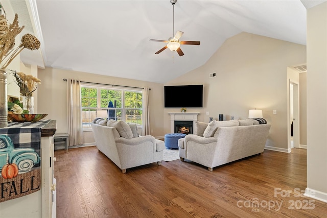 living room with ceiling fan, dark wood-type flooring, and vaulted ceiling