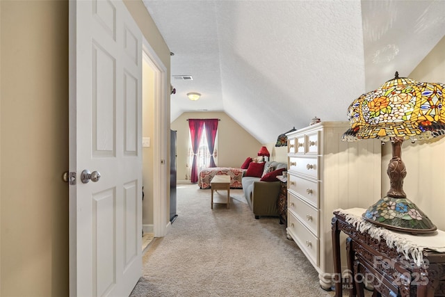 carpeted bedroom with a textured ceiling and vaulted ceiling