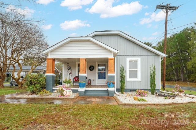 view of front facade featuring covered porch and a front yard