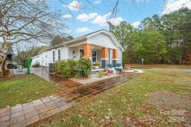 exterior space with covered porch and a front lawn