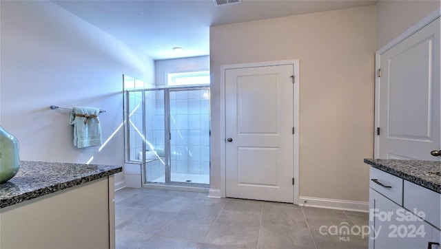 bathroom with tile patterned flooring, vanity, and a shower with shower door