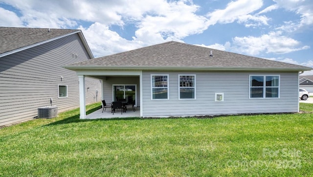 back of property with central AC, a patio area, and a yard