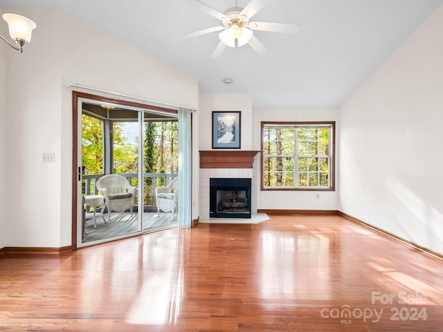 unfurnished living room featuring ceiling fan, light hardwood / wood-style floors, a healthy amount of sunlight, and a fireplace