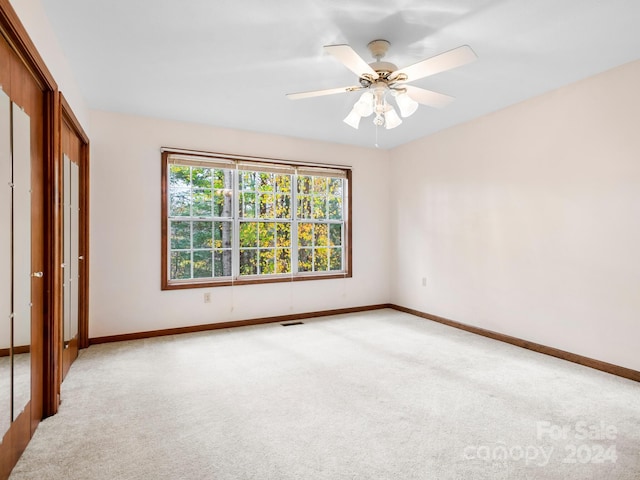 unfurnished bedroom featuring ceiling fan and light colored carpet