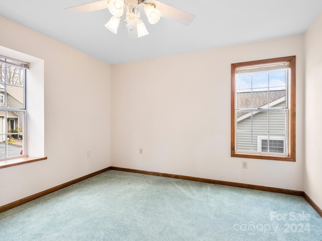 carpeted empty room with ceiling fan and plenty of natural light