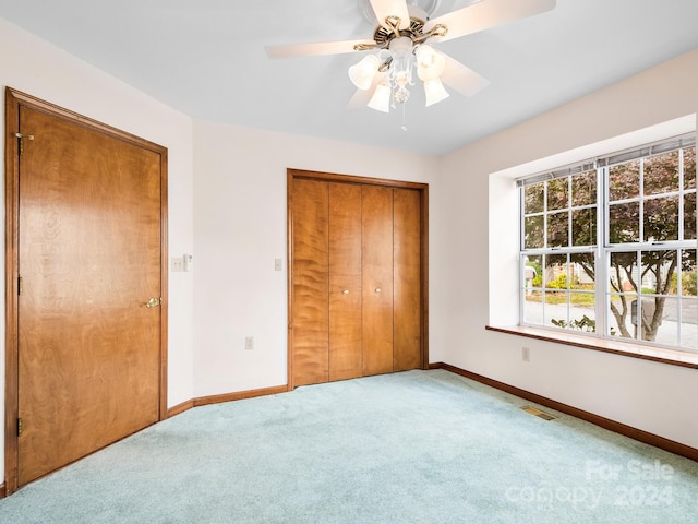 unfurnished bedroom featuring ceiling fan, a closet, and carpet floors