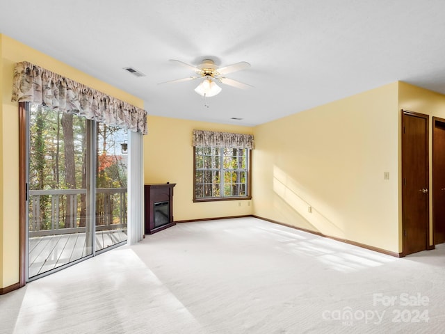 unfurnished living room featuring light colored carpet and ceiling fan