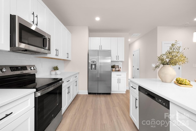 kitchen featuring white cabinetry, light wood-type flooring, and appliances with stainless steel finishes