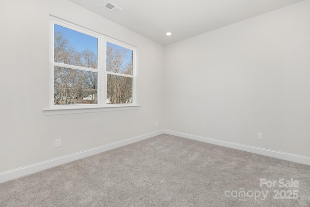 carpeted empty room with baseboards, visible vents, and recessed lighting